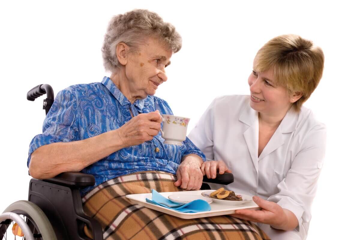Eine Betreuungskraft mit einer Seniorin